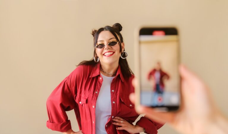 TikTok videók marketinghatékonysága Stylish trendy woman recording dance video for social media account on phone.