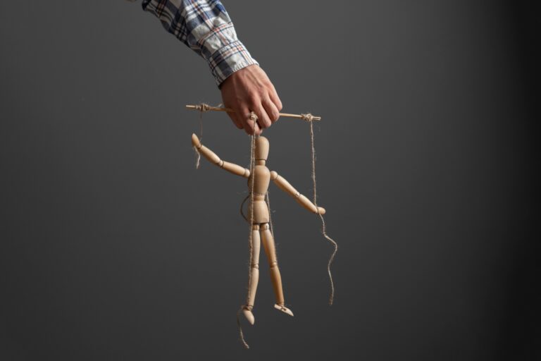 A manipuláció nem hazugság – hanem egy finoman torzított valóság the emploee holding a marionette wooden doll, manipulation concept