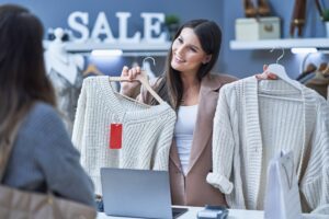 Woman seller and buyer in clothes store